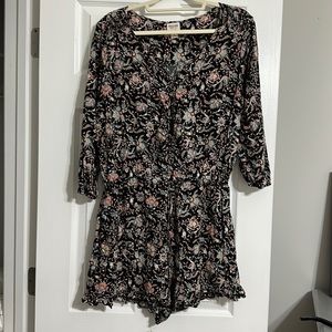 Black floral romper with 3/4 sleeve and tie waist.